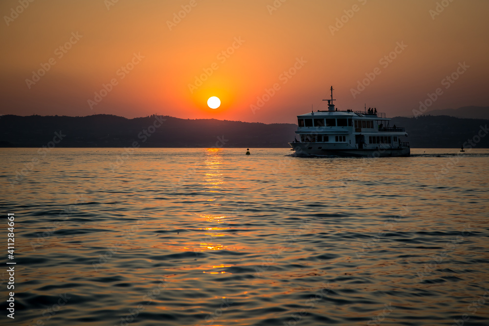 Passenger ship on the background of the sunset on Lake Garda. Lombardy, Italy