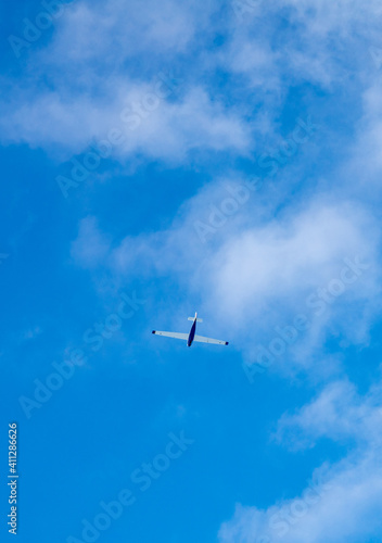 Small sport airplane in blue sky on sunny day