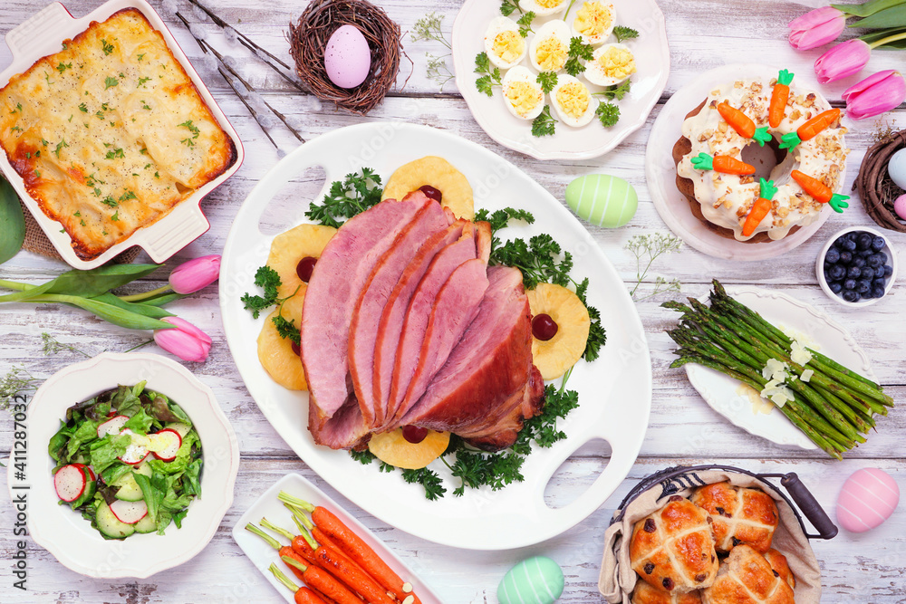 Traditional Easter ham dinner. Top view table scene on a white wood