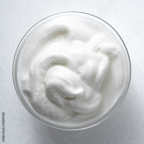 Sour cream sauce on a white background, top view.
