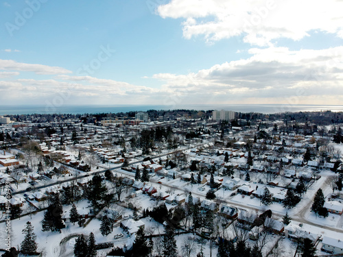 Aerial view of the city. Hundreds of houses bird eye top view suburb urban housing development. Quite neighbourhood covered in snow  Canada. Winter season.