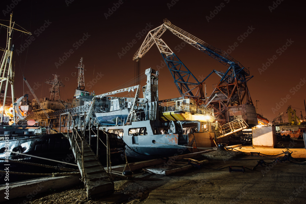 Fototapeta premium Cargo ship and cranes at night in port of Sevastopol, Crimea
