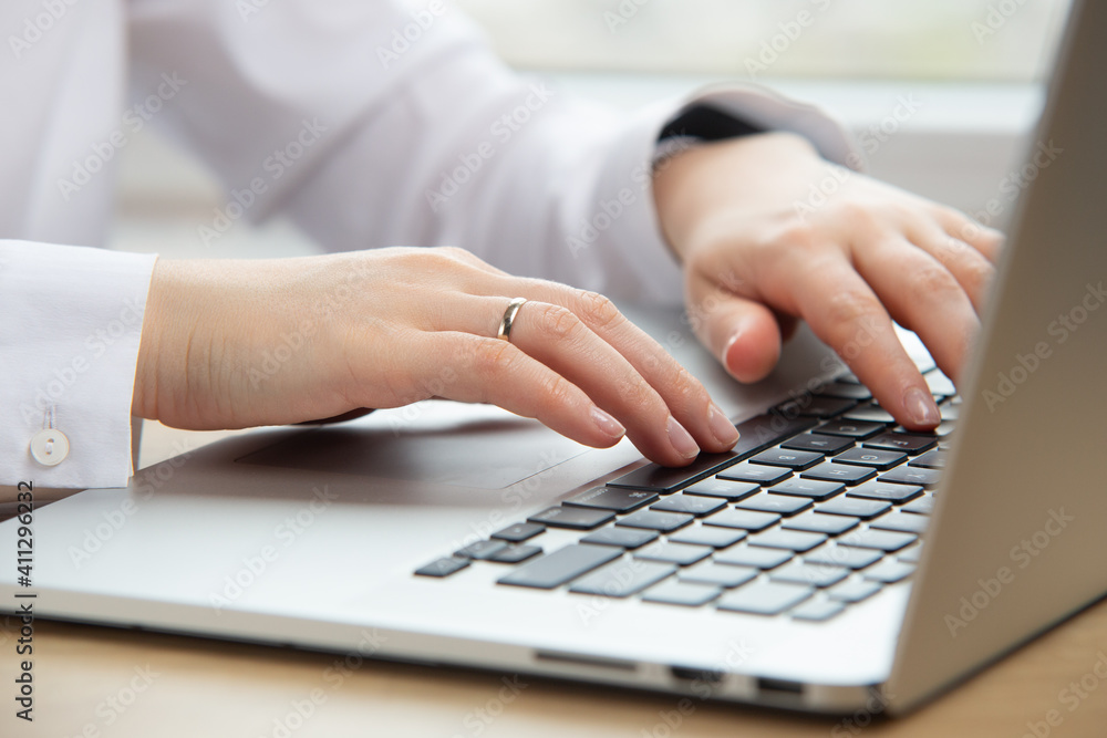 Woman hand working on a notebook using the touchpad. Working at home on quarantine. The business lady working in the office. Woman hand working on a notebook using the touchpad. Working at home on quarantine. The business lady working in the office.