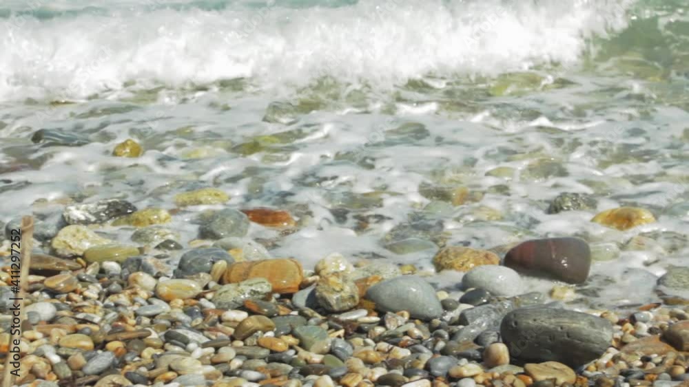 Sea waves close up. Waves with foam roll over the pebbles on the beach. Summer vacation concept. Vintage style Sea waves close up. Waves with foam roll over the pebbles on the beach. Summer vacation concept. Vintage style