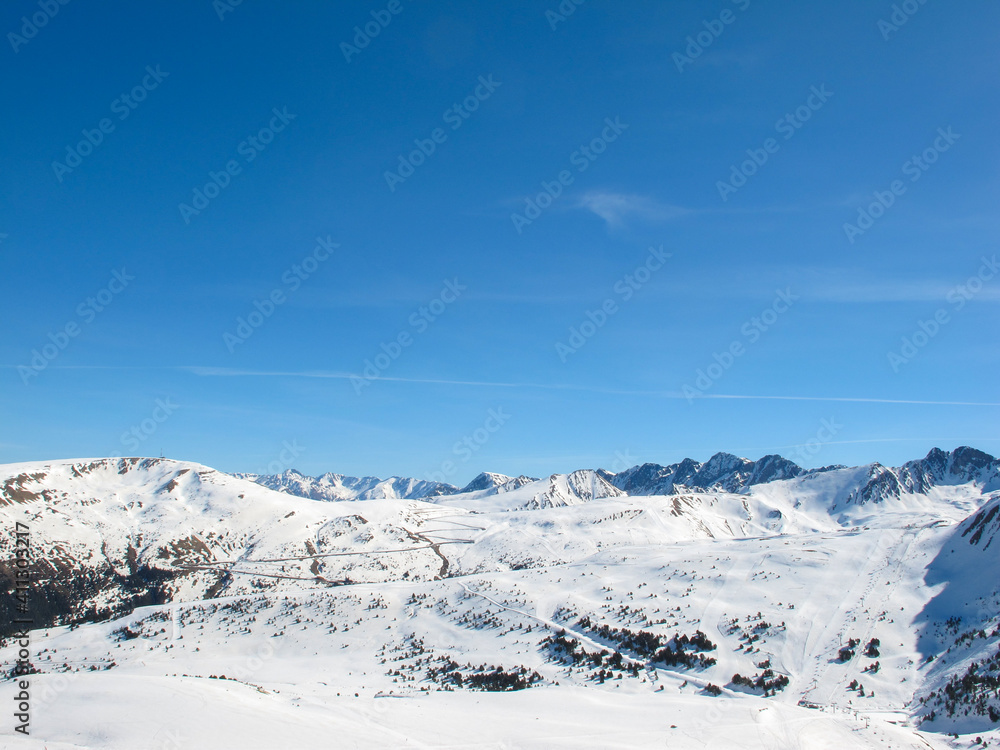 Snow-capped mountain peaks against a bright blue sky. Winter vacation. Sport and travel content. Snow-capped mountain peaks against a bright blue sky. Winter vacation. Sport and travel content.