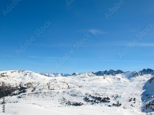 Snow-capped mountain peaks against a bright blue sky. Winter vacation. Sport and travel content.