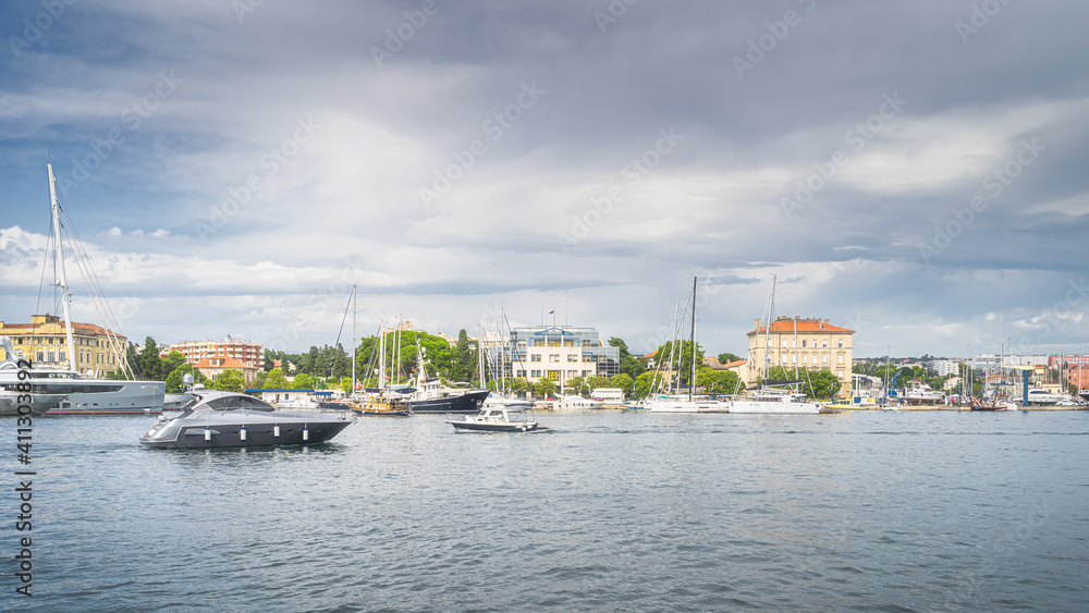 Motorboat entering Zadar bay from Adriatic Sea. Marina with moored yachts and sailboats, Croatia
