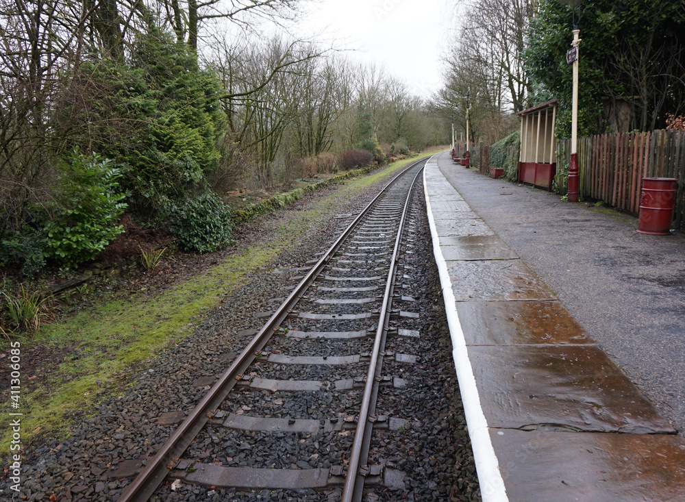 Fototapeta premium Rural single railway track and train station on a rainy day