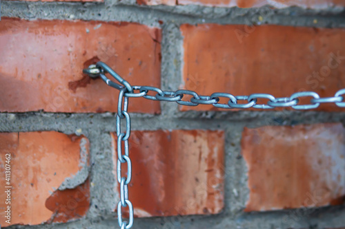 Quadro su tela the blurred chain is connected to a brick wal