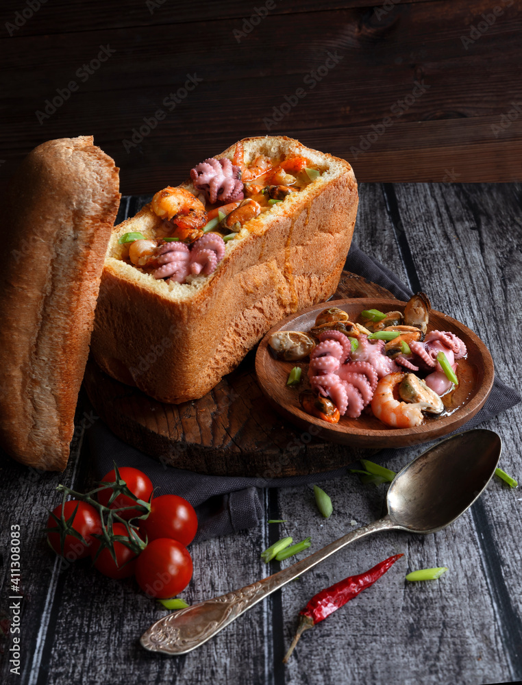 Traditional Icelandic fish soup with salmon and seafood in bread. An unusual pitch. Food Styling Traditional Icelandic fish soup with salmon and seafood in bread. An unusual pitch. Food Styling