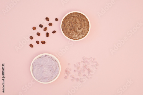 Various body scrubs. Coffee body scrub and lavender sea salt scrub. Spa treatments at home to relax and tighten the skin. Pink background, flat lay, top view