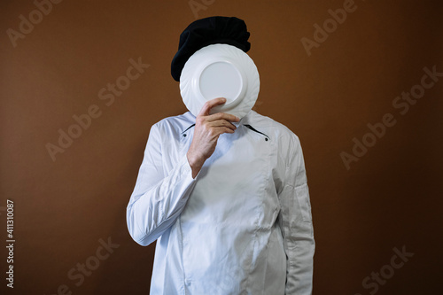 Male chef with an empty plate