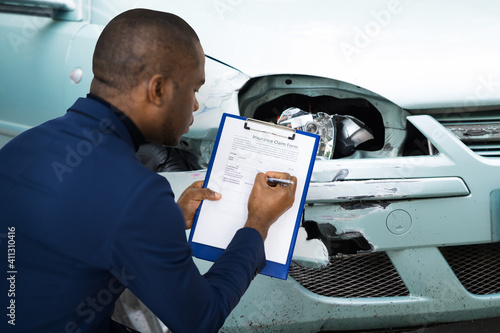 African American Car Insurance Agent Inspecting photo