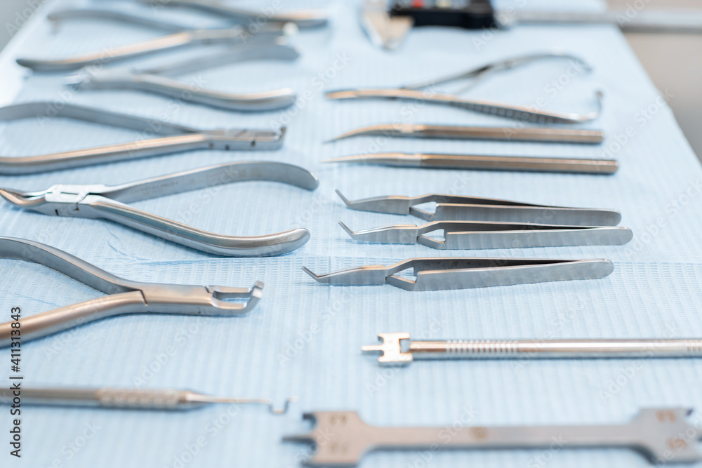 Dental tools and artificial jaw model for the orthodontic treatment lying on the table at the dental office, close-up. High quality photo Dental tools and artificial jaw model for the orthodontic treatment lying on the table at the dental office, close-up. High quality photo