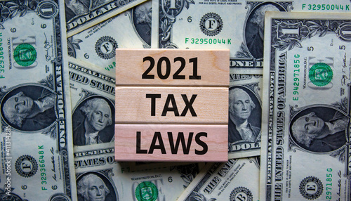 2021 tax laws symbol. Concept words '2021 tax laws' on wooden blocks on a beautiful background from dollar bills. Business and 2021 tax laws concept.