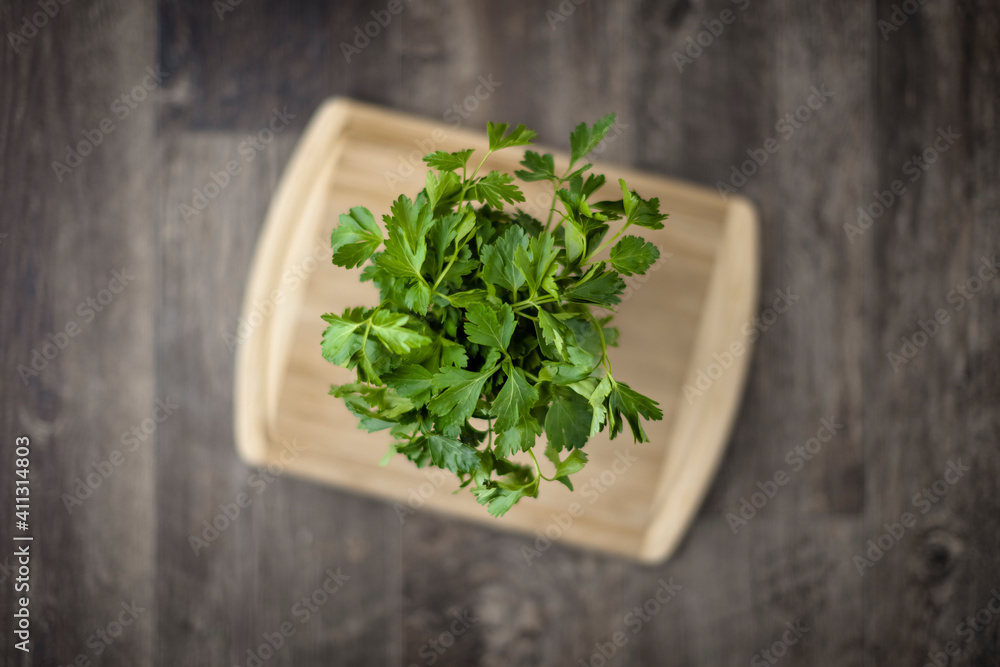 Parsley on cutting board on wood floor from above Parsley on cutting board on wood floor from above