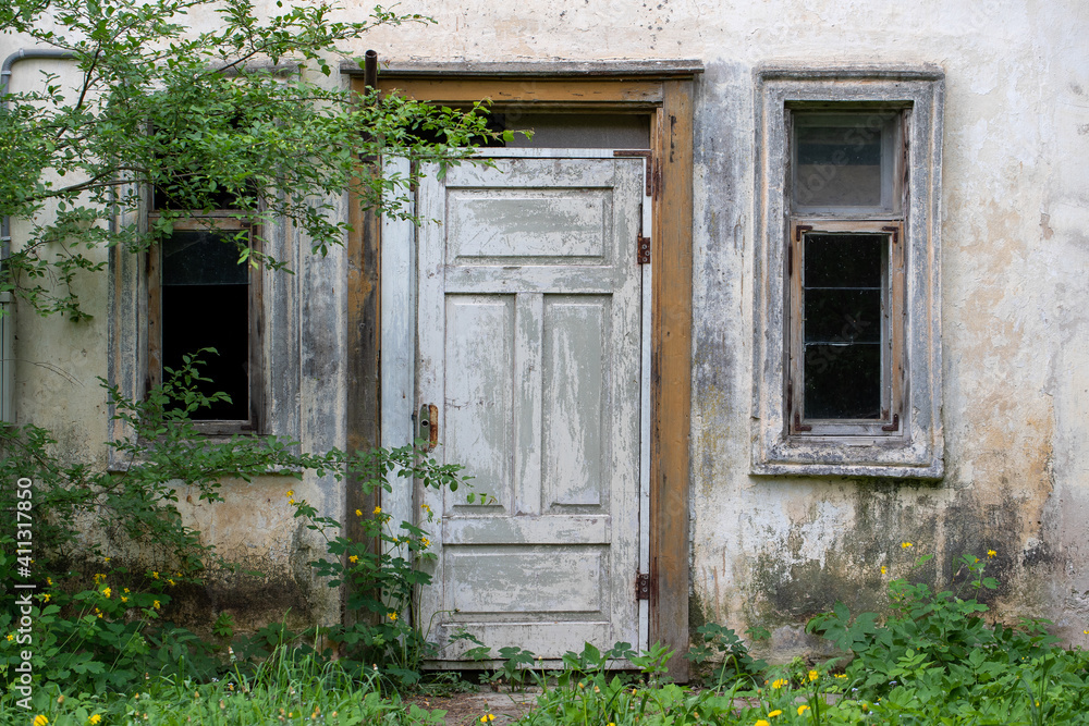 Gray and smoke building facade with doors and two old windows Gray and smoke building facade with doors and two old windows