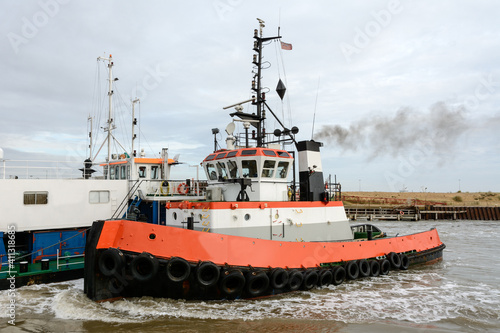 Tug towing (hipping) a dredger into the port of Great Yarmouth