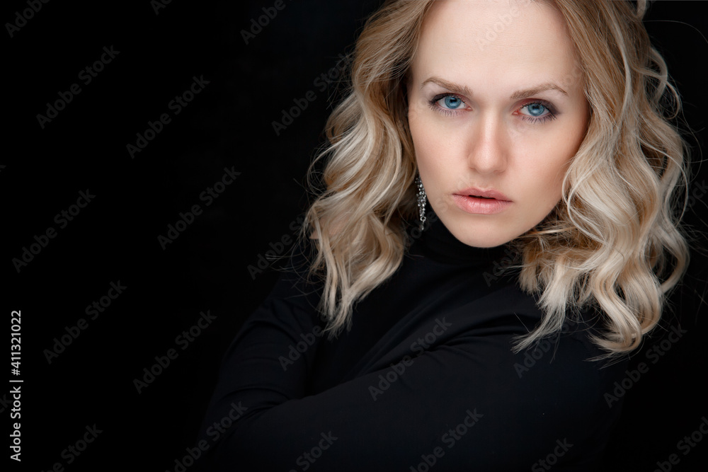 Close-up portrait of a white woman on a black background. Beautiful blue eyes, natural beauty of clean skin, facial and hair care. Strong, thick hair. Copy space Close-up portrait of a white woman on a black background. Beautiful blue eyes, natural beauty of clean skin, facial and hair care. Strong, thick hair. Copy space