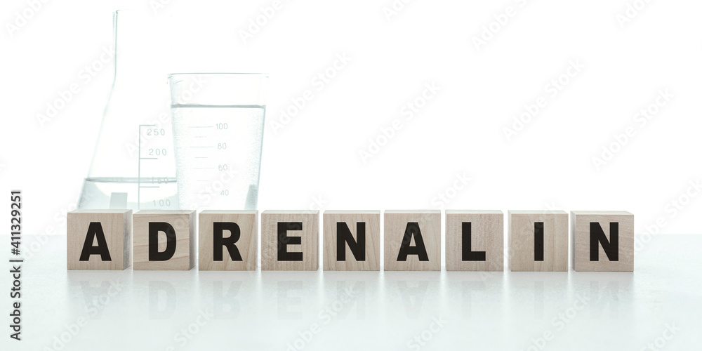 ADRENALIN word made with blocks on white background and chemical vessels with reagents. Medical concept. Banner. ADRENALIN word made with blocks on white background and chemical vessels with reagents. Medical concept. Banner.