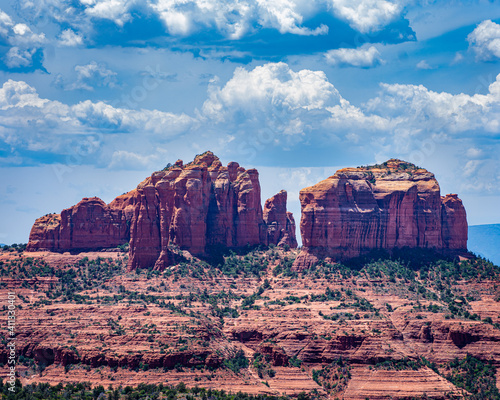 Montañas de peidras rojas en Arizona con nubes de fondo y con arboles pinos en el desierto photo