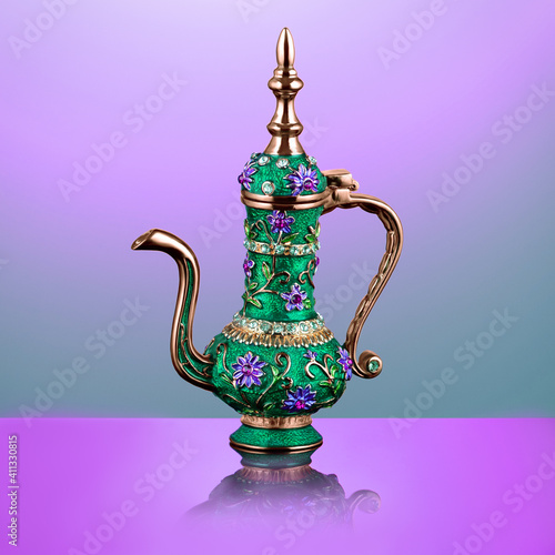 ornamented engraved oriental teapot with a long golden spout and a lid
