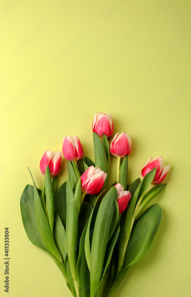 Fototapeta premium Spring concept, bouquet of tulip flowers on a light background. Women's day, Valentine's day concept, Mother's Day. Vertical position. Flat lay. Copy space.