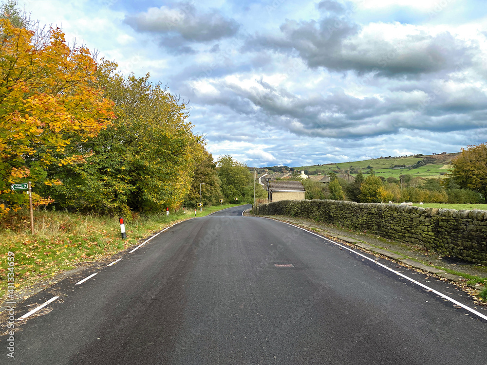 Looking along, Marsh Lane in autumn, with old trees, dry stone walls, and a cloudy sky in, Oxenhope, Keighley, UK Looking along, Marsh Lane in autumn, with old trees, dry stone walls, and a cloudy sky in, Oxenhope, Keighley, UK