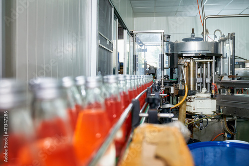 Inside of beverage industry automatic machine with product line of red juice