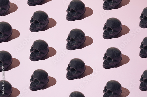 Dark gray skull candle on pink background. Pattern.