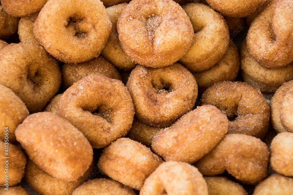 Photography of many sweet donuts with cinnamon and sugar, tasty sweet snack food.