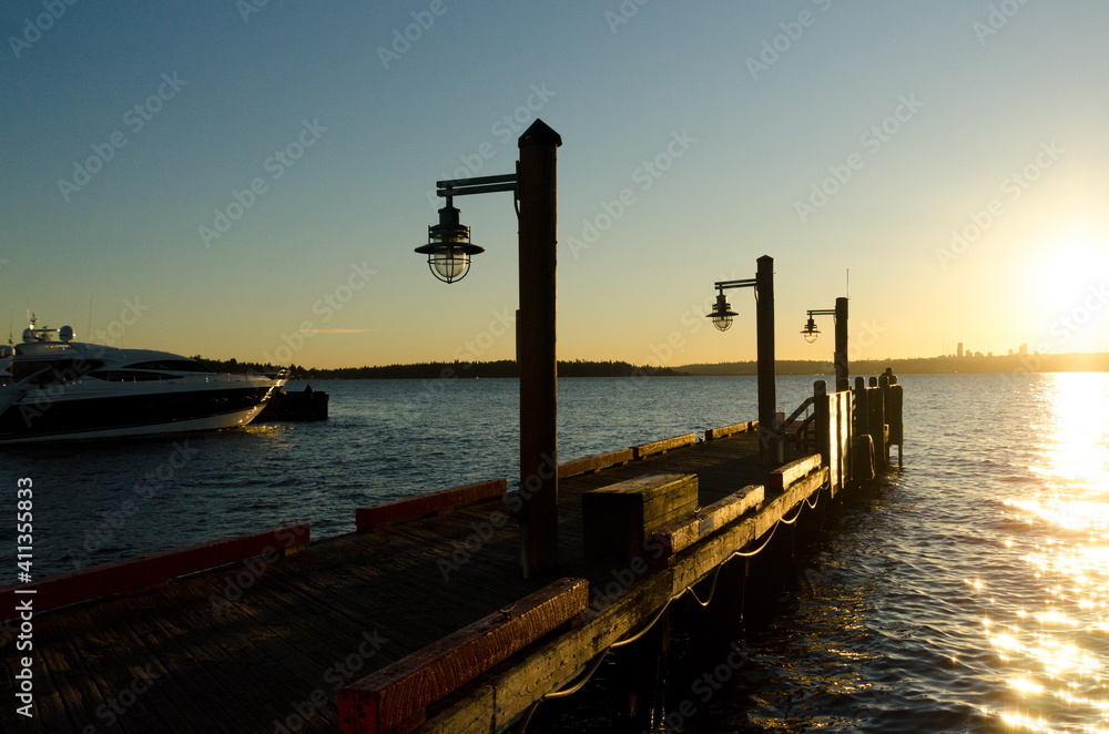 Silhouettes and lamp posts on wooden pier  during  winter sunset
