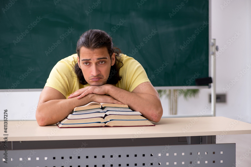Young male student preparing for exams in the classroom Young male student preparing for exams in the classroom