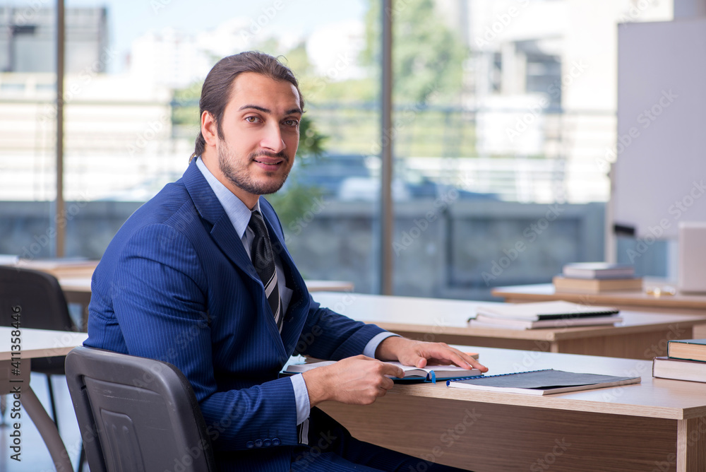 Young male teacher in suit in the classroom Young male teacher in suit in the classroom