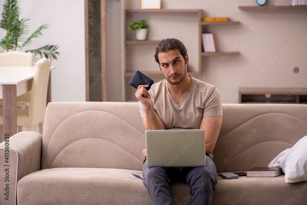 Young male freelancer holding wallet at home Young male freelancer holding wallet at home