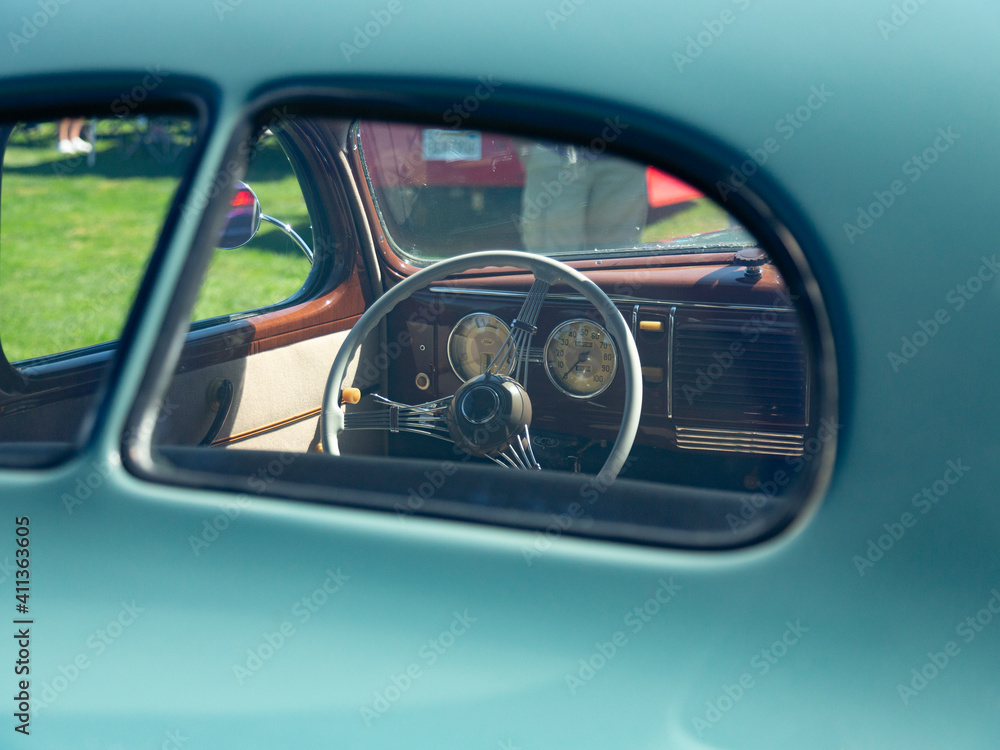 The View of Restored Vintage Automobile Dashboard Steering Wheel Through the Backside of a Split Window