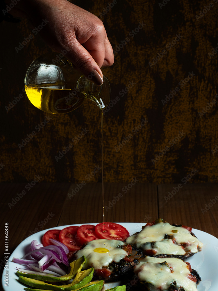 Hongos portobello gratinados con ensalada de aguacate, tomate, cebolla morada y aceite de oliva