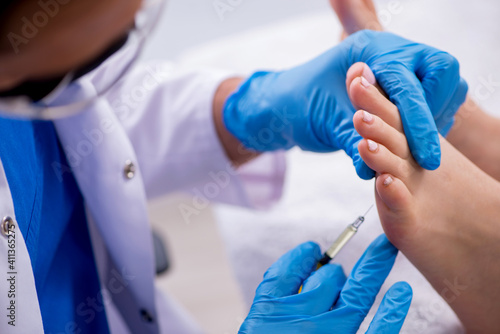 Podiatrist treating feet during procedure