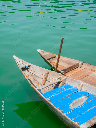 Pair of traditional wooden Vietnamese sampan rowboats on calm water © Cameo