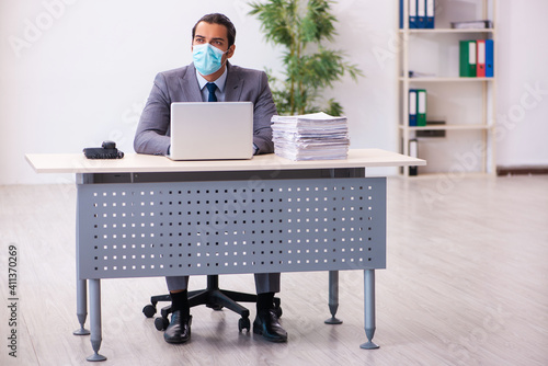 Young male employee wearing mask during pandemic