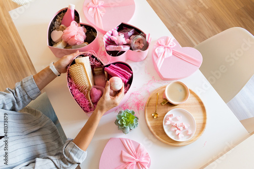 Young woman packing gift box set of natural spa kit, bath amenities for Mother's and Valentines Day