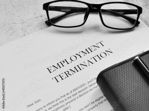 Employment Termination letter with pen,eye glasses and book.  photo