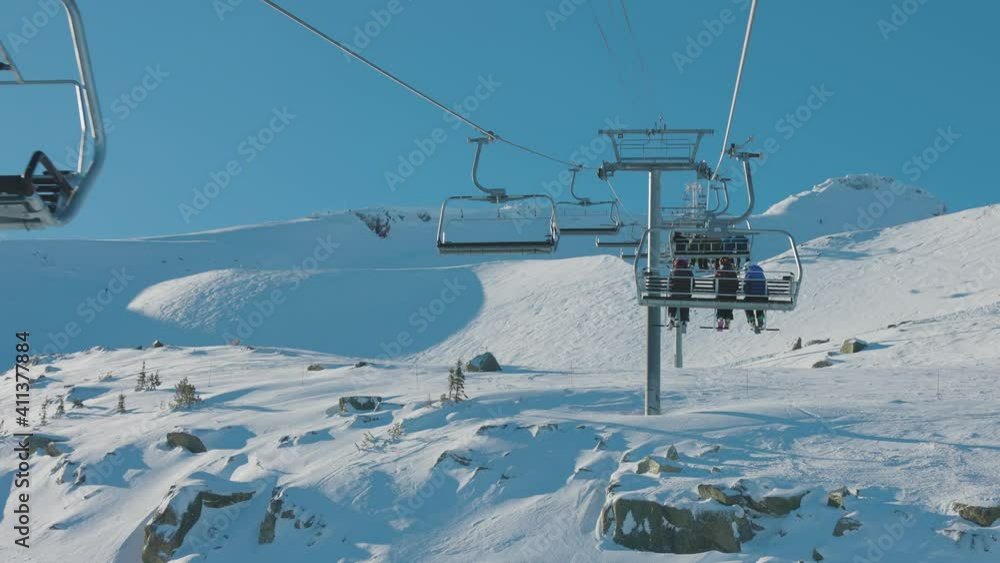 Whistler Ski Resort, British Columbia, Canada. Beautiful View of the snowy Canadian Nature Landscape Mountain and Chairlift going to the peak during a vibrant winter morning. Slow Motion Whistler Ski Resort, British Columbia, Canada. Beautiful View of the snowy Canadian Nature Landscape Mountain and Chairlift going to the peak during a vibrant winter morning. Slow Motion