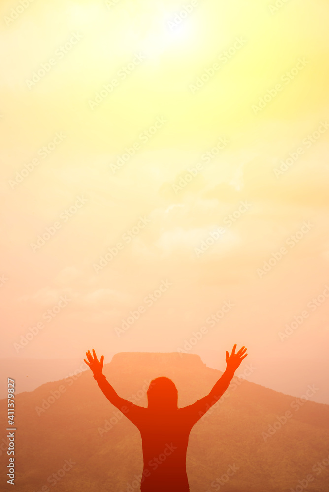 A man raising his arms on the mountain