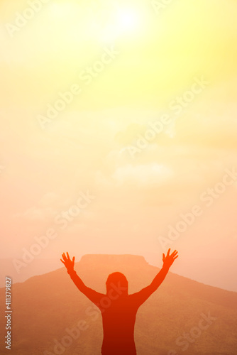 A man raising his arms on the mountain