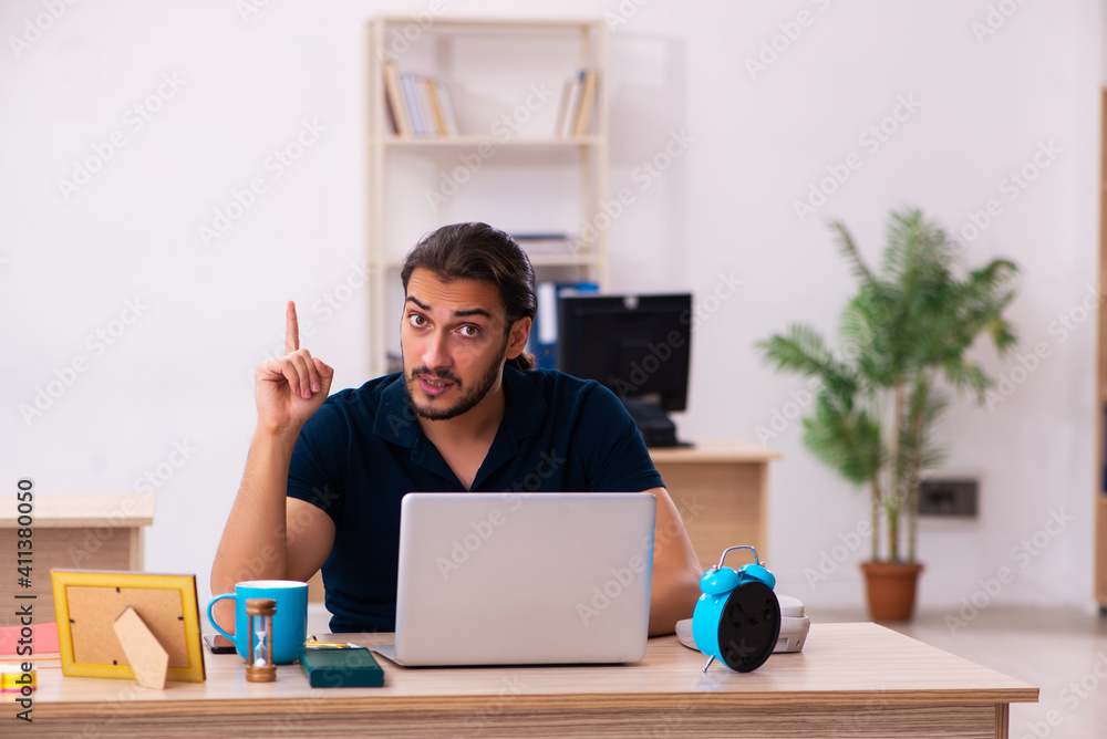Young male employee working at workplace Young male employee working at workplace