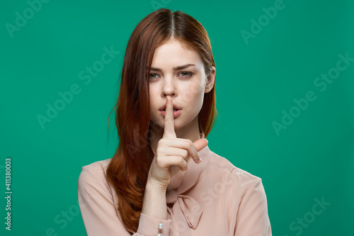 pretty cheerful woman holds her hand on her face attractive look Green background