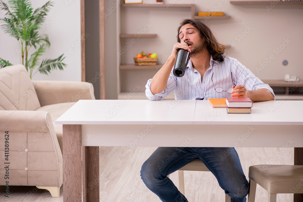 Young male student drinking alcohol at home Young male student drinking alcohol at home