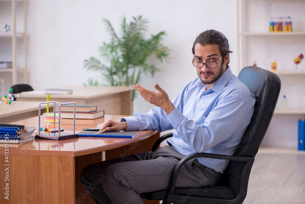 Young male teacher physicist in the classroom Young male teacher physicist in the classroom