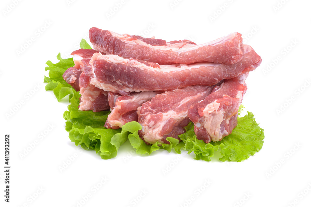 Raw pork ribs on a lettuce leaf are isolated on a white background.